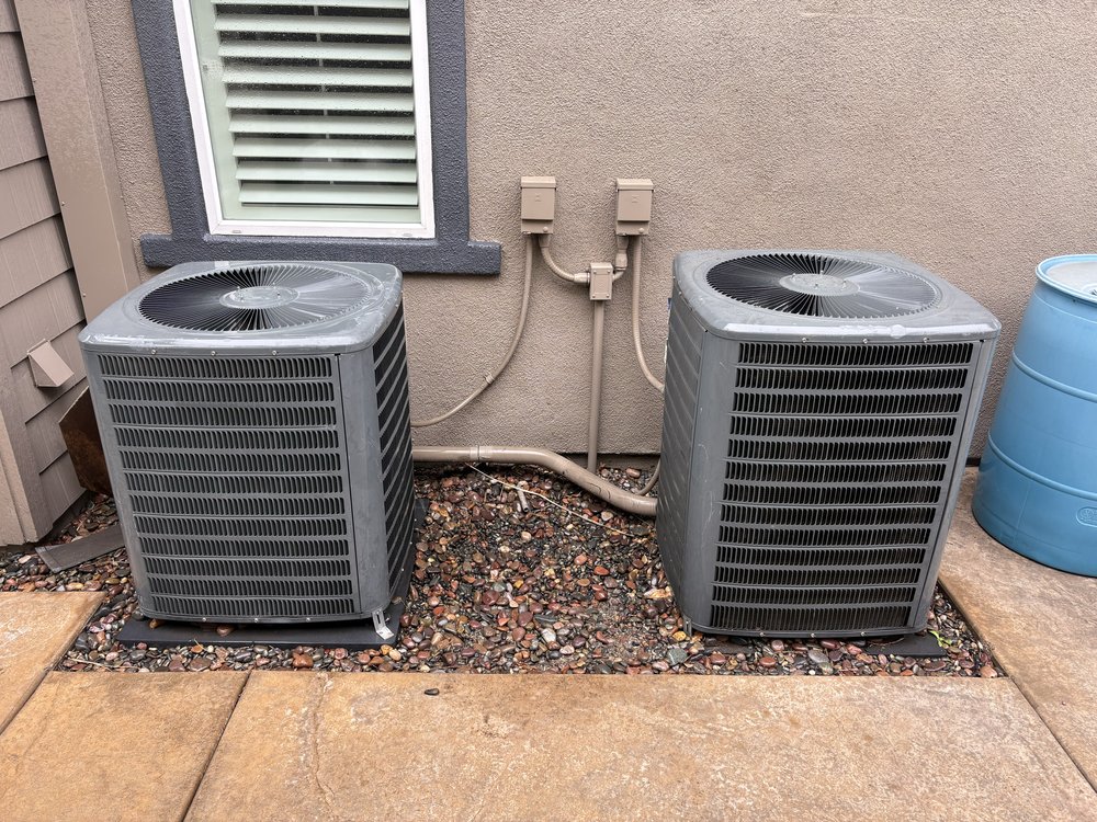 Two outdoor AC condenser units installed at a residential home