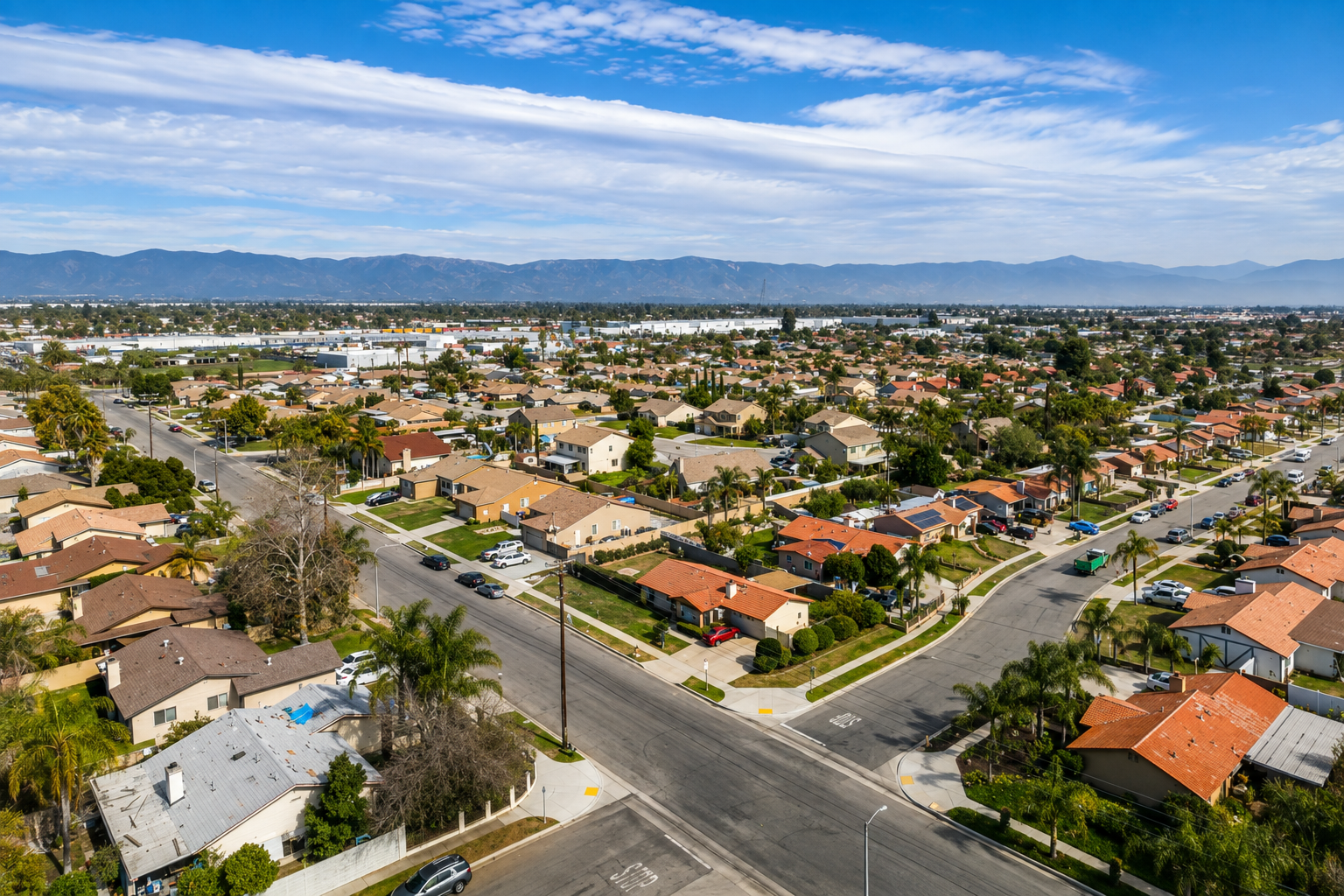 Aerial view of Bloomington, California neighborhood with homes and nearby mountains